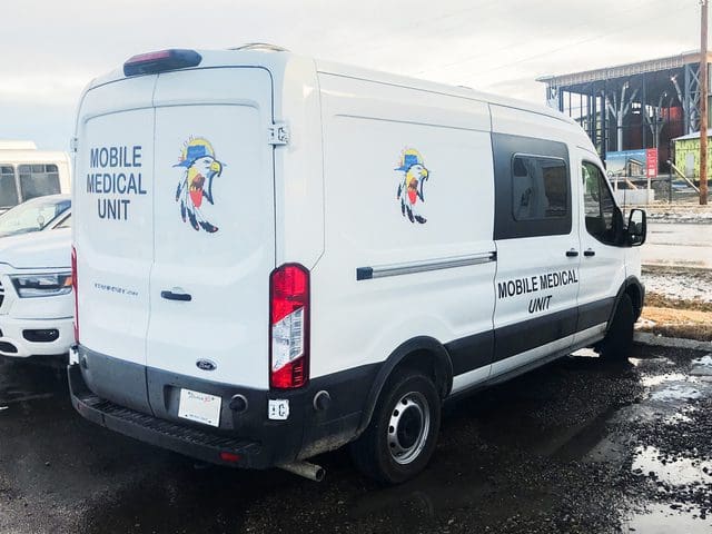 Blood Tribe Department of Health Mobile Medical Unit program van parked in community centre parking lot
