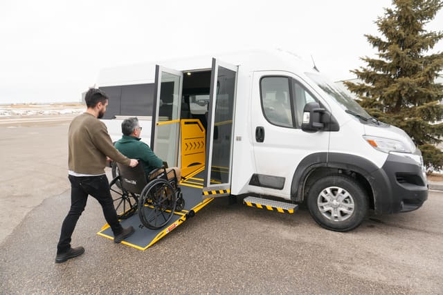 Man loading a wheelchair user into a MoveMobility P4 Van